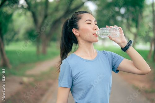 Asian women drink water after exercising