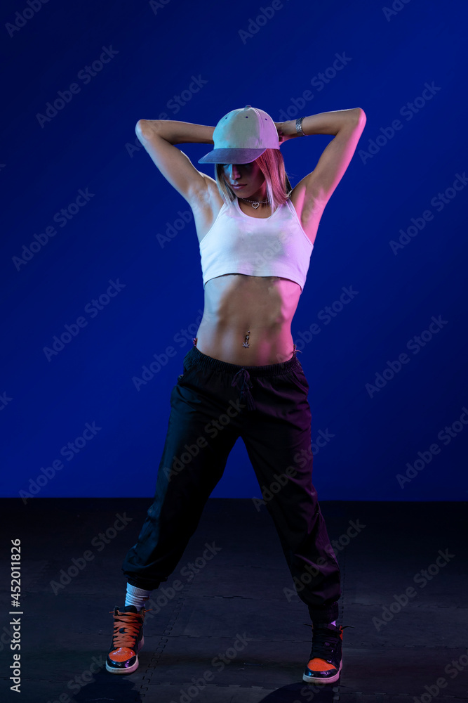Portrait of a latin woman with pants and red cap, in a studio with blue background Portrait of a latin woman with pants and red cap, in a studio with blue background