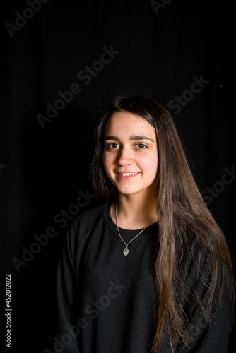 portrait of teenage girl with black background -smiling girl with long hair portrait-