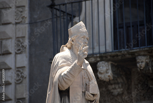 The statue from behind of St. James the Confessor at the entrance of the Catania cathedral and the palace of the Seminary of the Clerics.

 photo