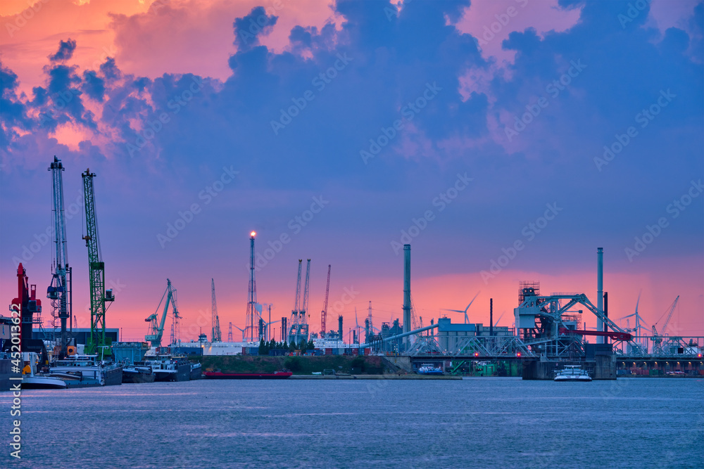 Port of Antwerp with harbor cranes in twilight