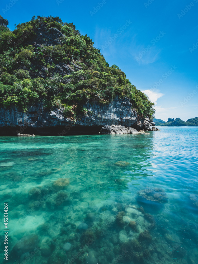 Stunning rocky island with coral reef underneath crystal clear water