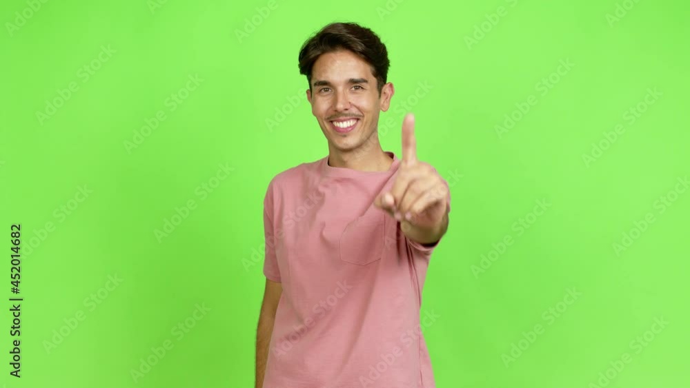 Young man showing and lifting a finger in sign of the best over isolated background. Green screen chroma key Young man showing and lifting a finger in sign of the best over isolated background. Green screen chroma key
