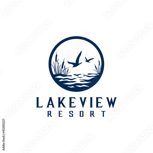 Flying seagull over water, background typha plant logo design