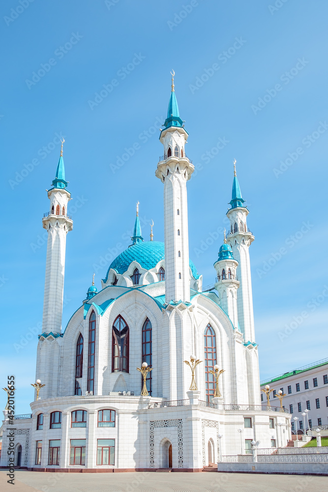 Beautiful white mosque with a blue roof against the blue sky.