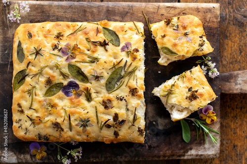 Foto Freshly baked focaccia with herbs and flowers
