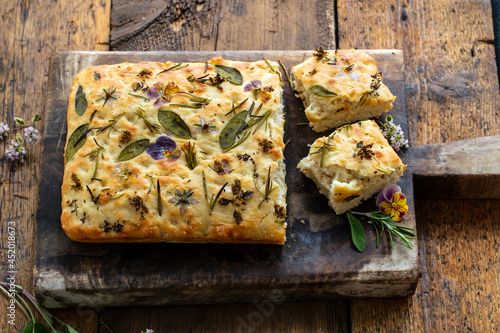 Freshly baked focaccia with herbs and flowers photo