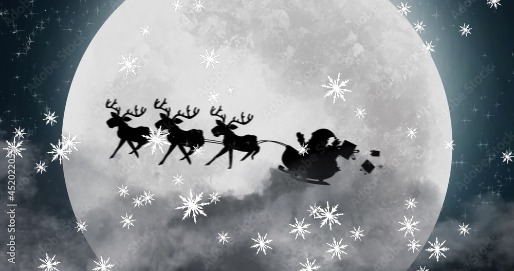 Fototapeta premium Image of black silhouette on santa claus in sleigh being pulled by reindeer with winter scenery 