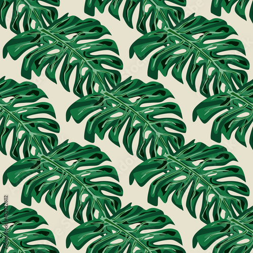 Fototapeta Naklejka Na Ścianę i Meble -  Green hand drawn tropic palm monstera leaves seamless doodle pattern. Pastel grey background.