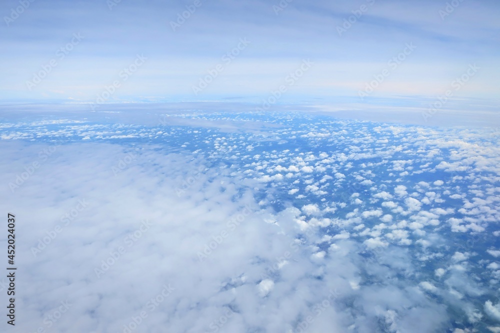 Blue sky with white cloud in summer time. Aerial view from airplane's window. Nature background concept with copy space.
