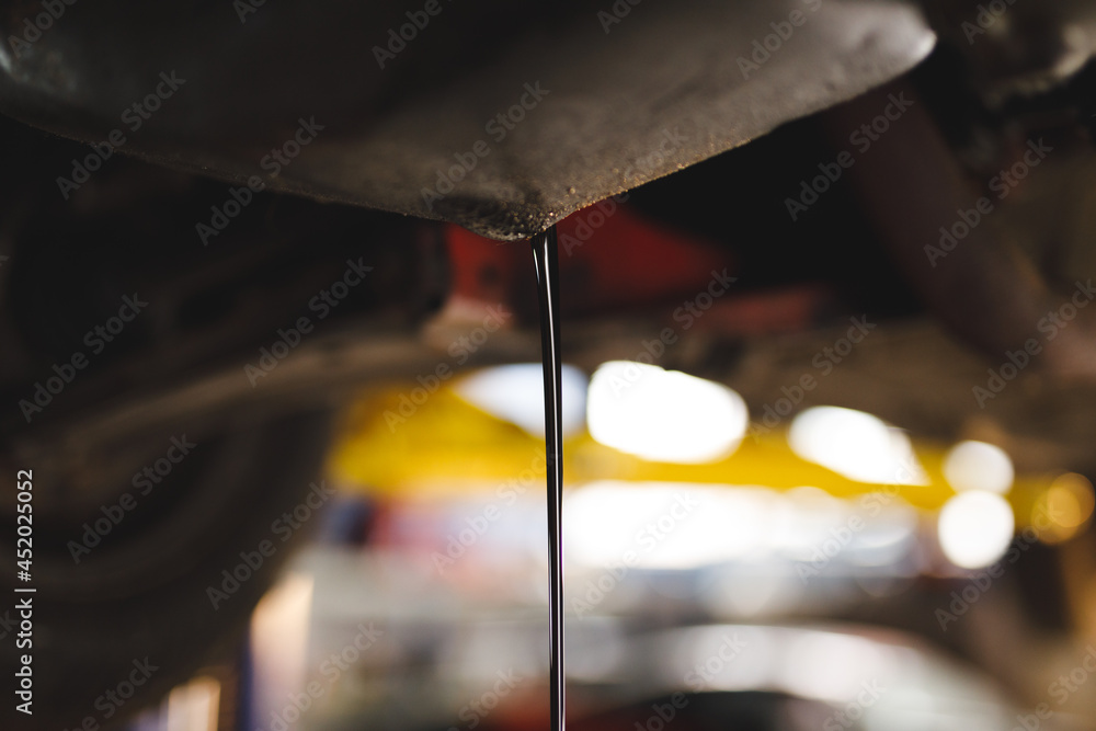 Close up of oil pouring out of car Close up of oil pouring out of car