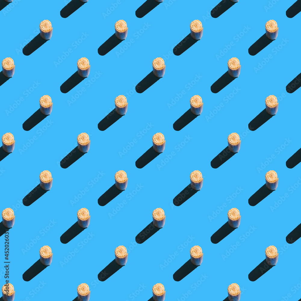 Pattern waffle roll cookies on blue background Pattern waffle roll cookies on blue background