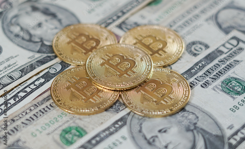 Concepto de monedas de Bitcoin sobre manto de dólares americanos y apariencia de oro Concepto de monedas de Bitcoin sobre manto de dólares americanos y apariencia de oro