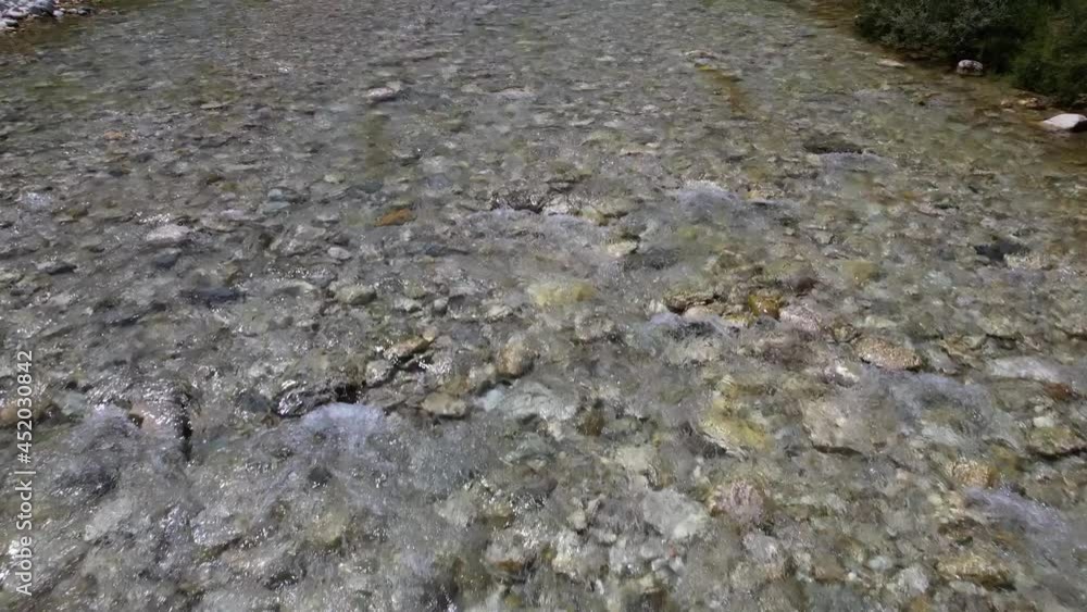 Riverbed texture with clean water of creek streaming over stones on high mountain area in Albania Riverbed texture with clean water of creek streaming over stones on high mountain area in Albania