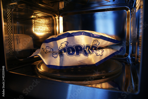 Hot popcorn in the microwave, food for watching a movie.