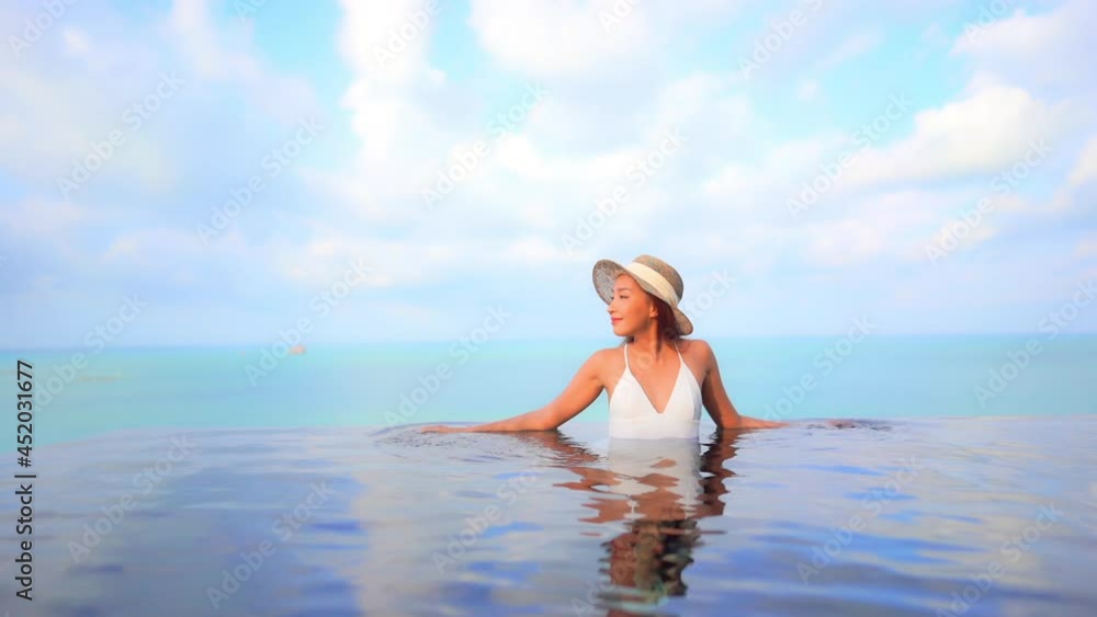 Fit Woman Model in White Swimming Suit Leaning Arms on the Edge of Infinity Pool on Turquoise Seascape Background in Thailand on a Sunny Day Slow Motion Fit Woman Model in White Swimming Suit Leaning Arms on the Edge of Infinity Pool on Turquoise Seascape Background in Thailand on a Sunny Day Slow Motion