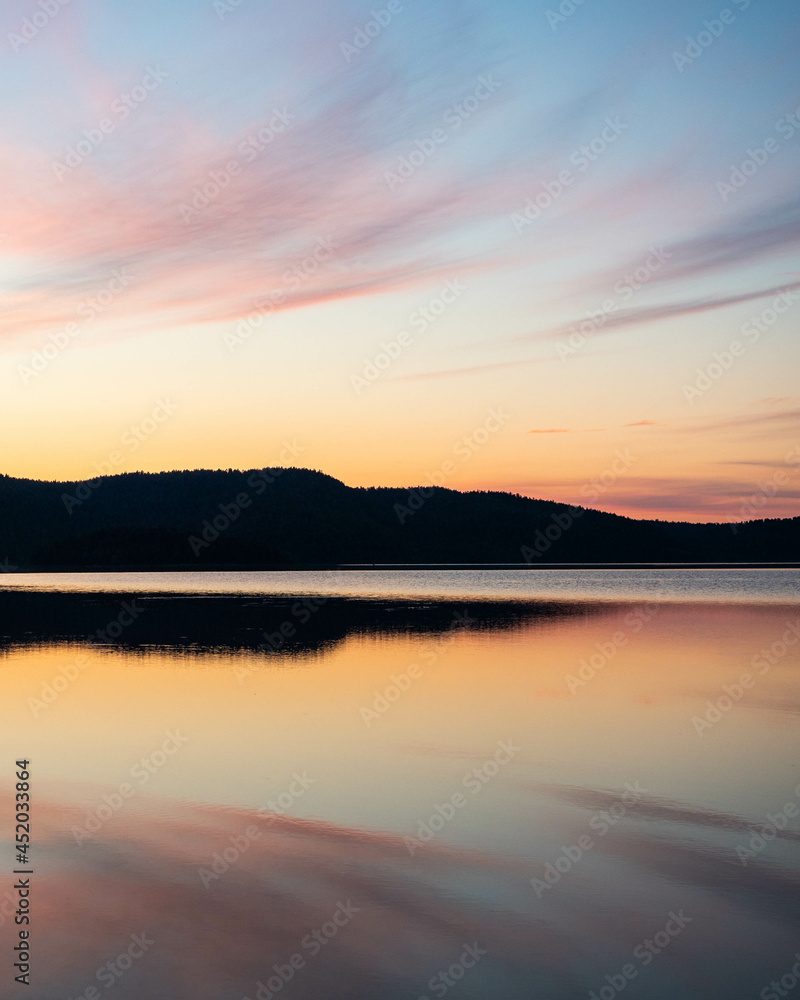 Reflection of pink sky on a lake in Lemmenjoki National Park, Finnish Lapland