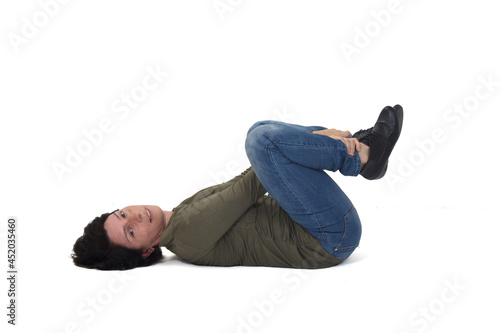 woman sitting on the floor looking at camera and showig her legs on white background