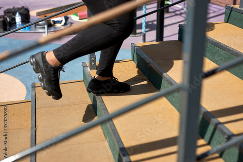 cropped african woman running up stairs with concentrated motivated expression, doing cardio training outdoors, jogging workouts for weight loss, burning fat, calories. Health care concept. Copy space