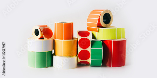 Colored and white reels with self-adhesive labels for printers. photo