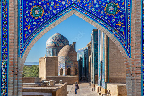 View over the mausoleums and domes of the historical cemetery of Shahi Zinda through an arched gate, Samarkand, Uzbekistan photo