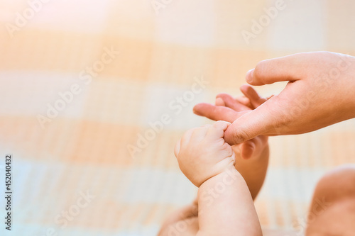 Newborn child holds a mother's finger, close-up concept love. Hands of mother and baby closeup. The Touching Lovely Moment. Concept of support, hope, love, bonding, care