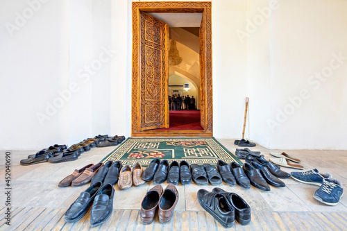 Shoes taken off to get in the mosque with people praying in the background, Samarkand, Uzbekistan