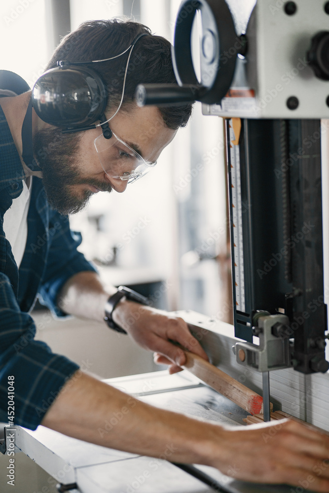 Professional carpenter working with sawing machine Professional carpenter working with sawing machine