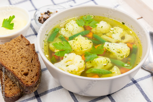 Vegetable soup with cauliflower, carrots and string beans.