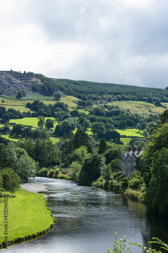 Dee river valley, Wales. Beautiful landscape view of idyllic countryside. Green fields and hills with the graceful river flowing. Welsh rural scene on a summers day.