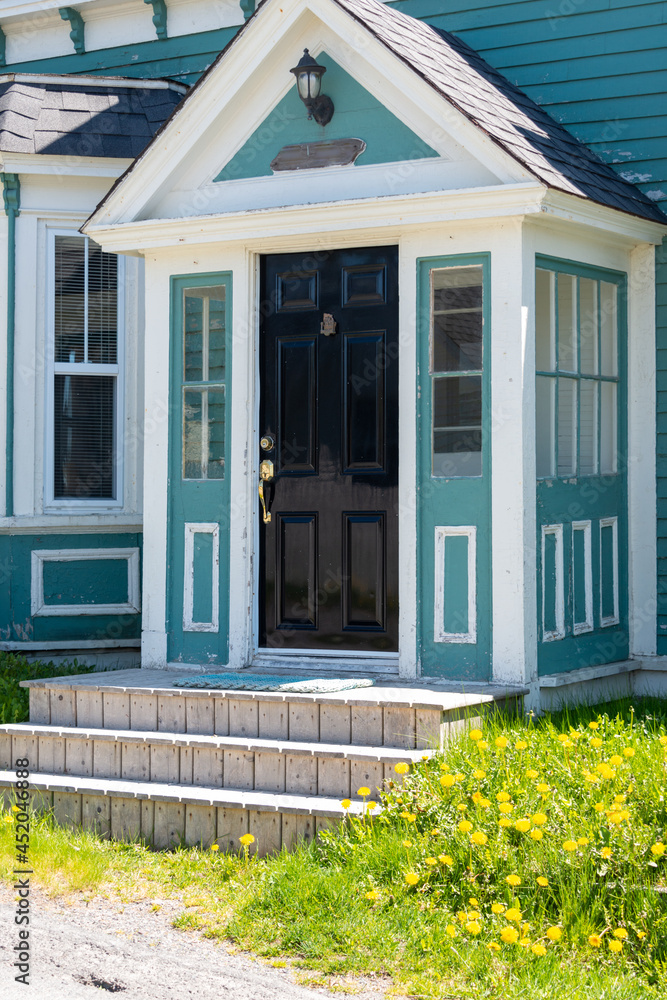 Φωτογραφία The exterior of a vintage colonial style teal green wooden building with white decorative trim