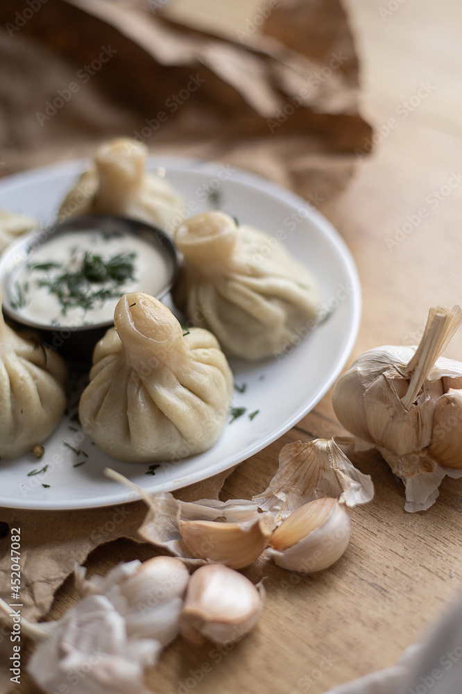 khinkali with sauce on a plate and garlic khinkali with sauce on a plate and garlic