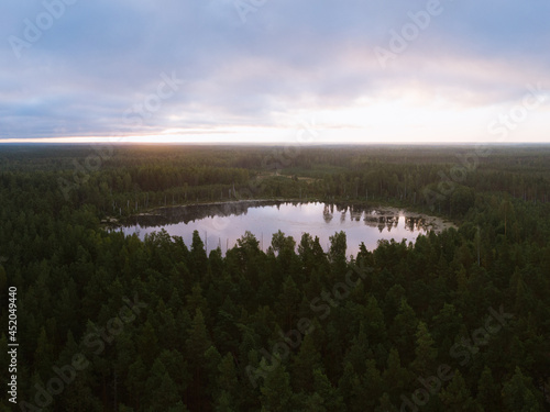 Lake in the woods with a clouds in the sky shot at the sunrise