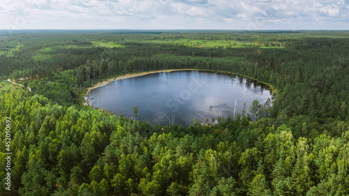 Aerial view on the round lake with reflections of the sky on it