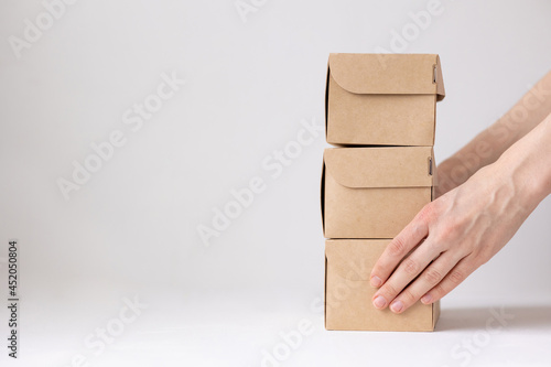 Kraft cardboard boxes, food or clothing delivery, modern ways to buy food with delivery, online store with home delivery, women's hands holding boxes of food or an order from an online store, online © MyJuly