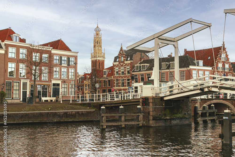 Cityscape of the center of the historic Dutch city of Haarlem, with the Gravesteen bridge over the Spaarne in the foreground and the tower of the Bakenesserkerk in the background.