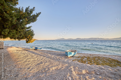 Fototapeta Naklejka Na Ścianę i Meble -  Blue fishing boat on an empty beach in Gradac, Croatia