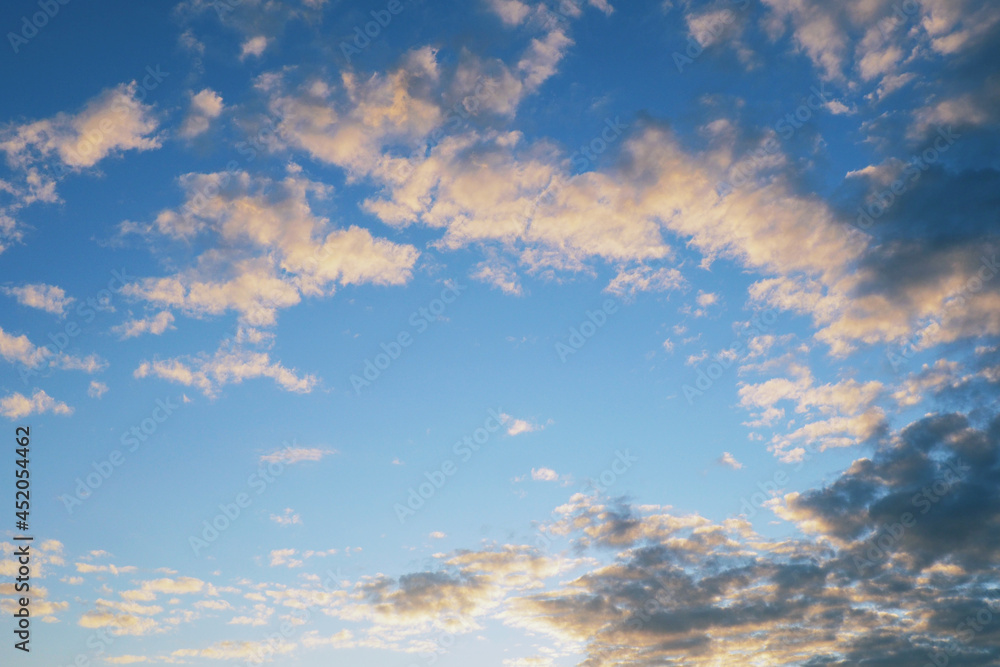 Blue sky, light and dark clouds at sunset. Cloudscape background or wallpaper. End of a sunny summer day Blue sky, light and dark clouds at sunset. Cloudscape background or wallpaper. End of a sunny summer day