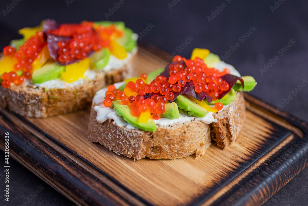 bruschetta sandwiches with avocado and red caviar