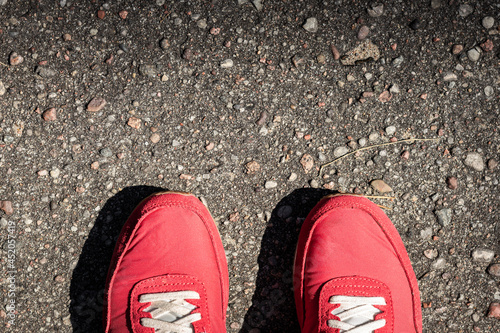 Czerwone sportowe buty na asfalcie. 