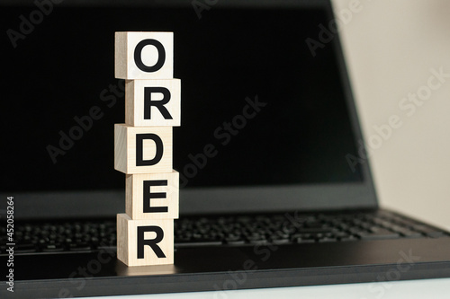 Letter block in word order on wood background, wooden block on computer keyboard against black background