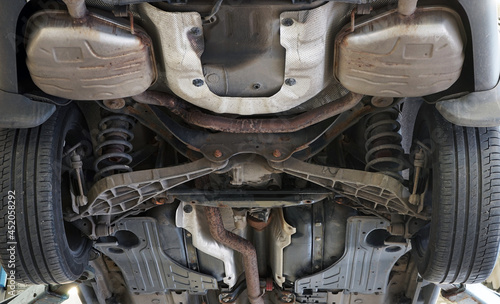 Bottom view of a modern car. The structure and elements of the rear suspension, details of the exhaust system.