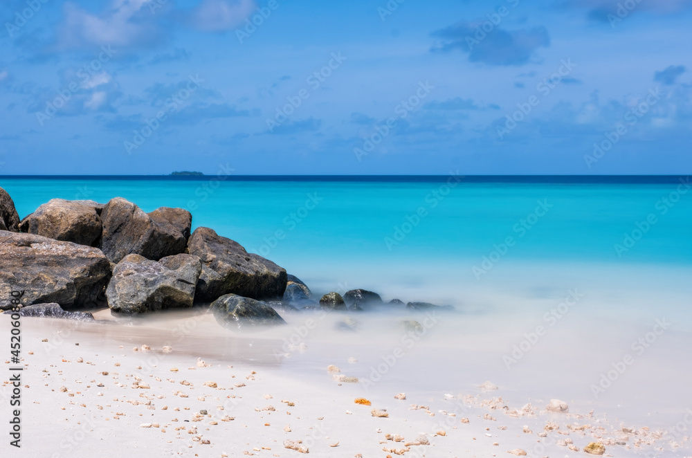 Long exposure water of Indian ocean with stones on the Maldivian island. Crossroads Maldives, july 2021
