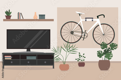 Bike hanging on the wall in living room. Living room interior with TV, flowers in pots, and a bicycle.