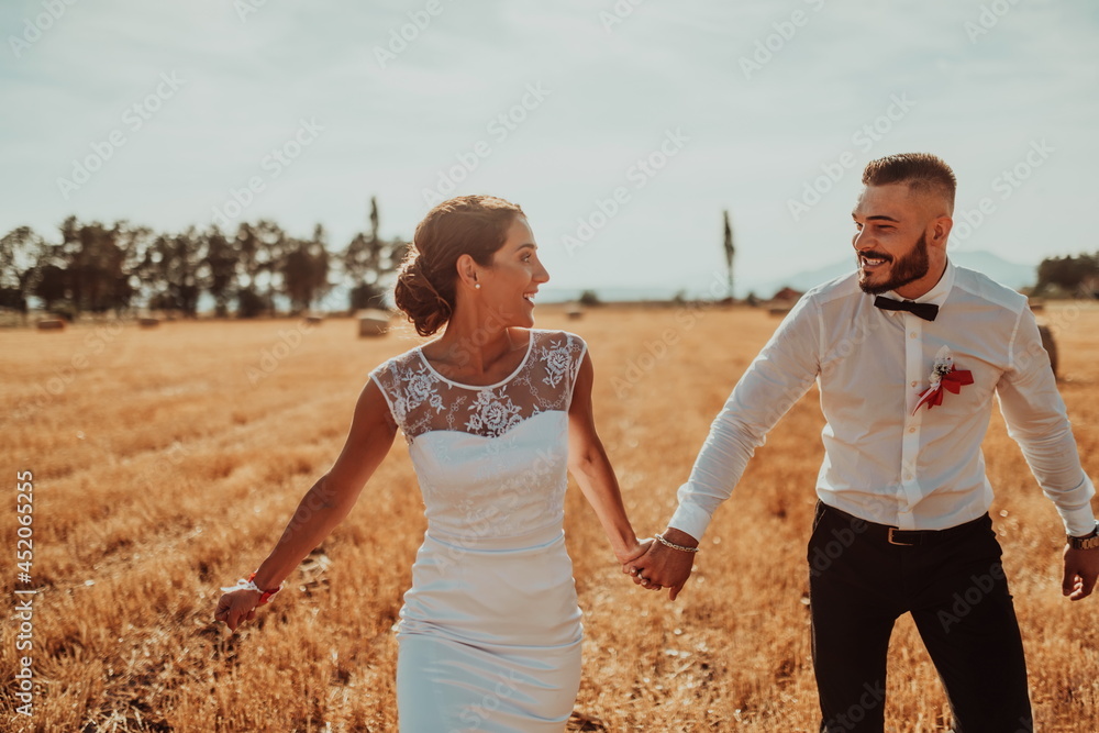 a young married couple in a large field enjoys the sunset. Selective focus