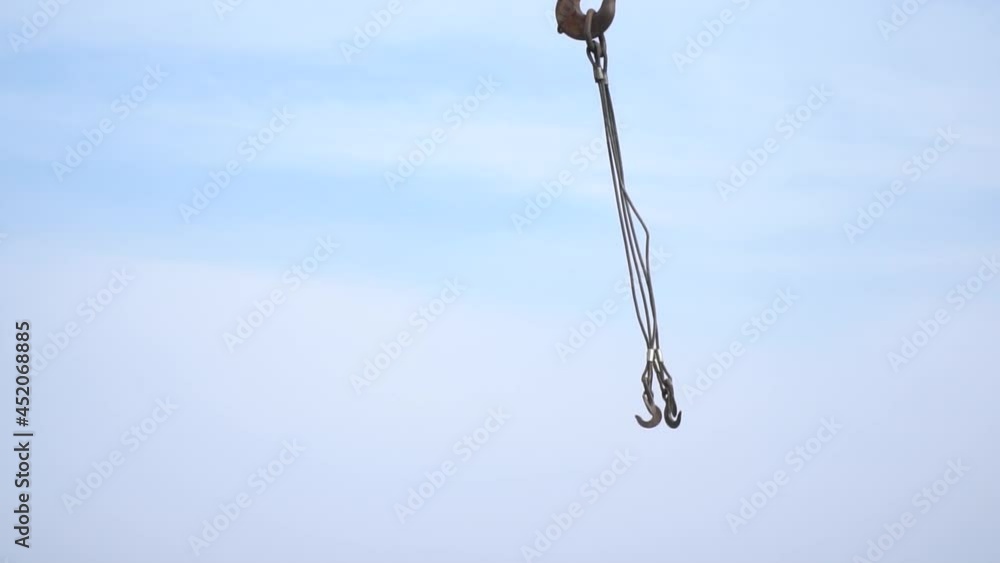 Huge industrial crane is moving its hooks around, heavy machinery Huge industrial crane is moving its hooks around, heavy machinery