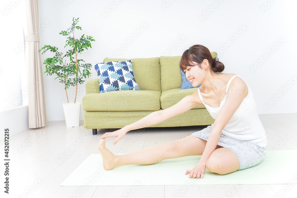 部屋でストレッチをする女性 部屋でストレッチをする女性