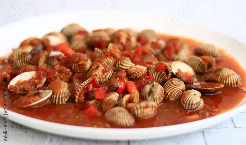 Kerang saus padang or Indonesian Chili Oyster on white plate.  photo