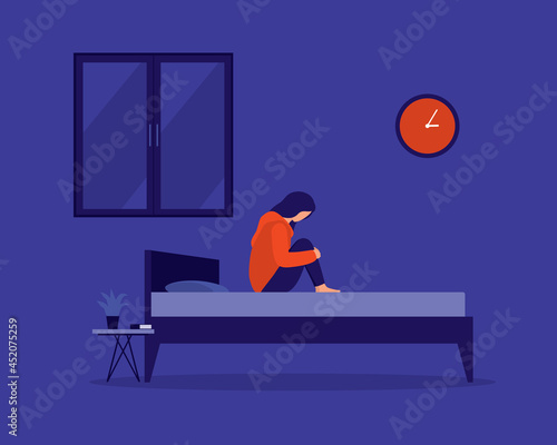 Young Depressed Woman Hugging Her Knees And Sitting On Her Bed, Staying Awake And Having Trouble Sleeping At Night. Insomnia.