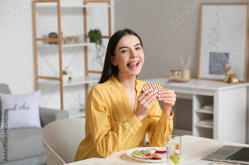 Beautiful young woman eatin...